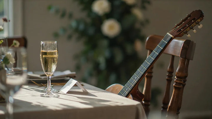 Acoustic guitar resting by a folded place card and champagne glass on a wedding reception table