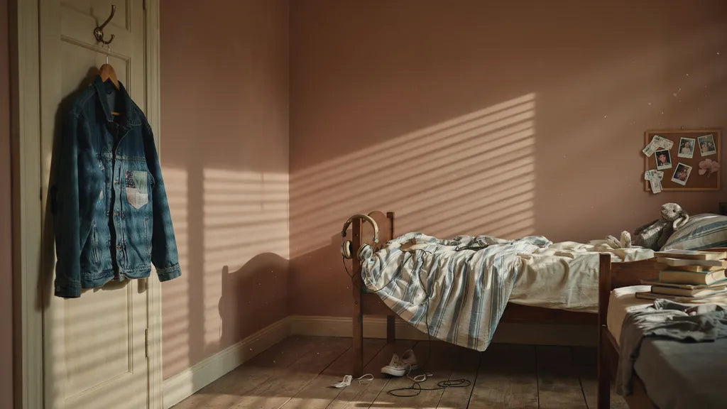 A worn jacket and headphones in a shared childhood bedroom — memorial song for a brother