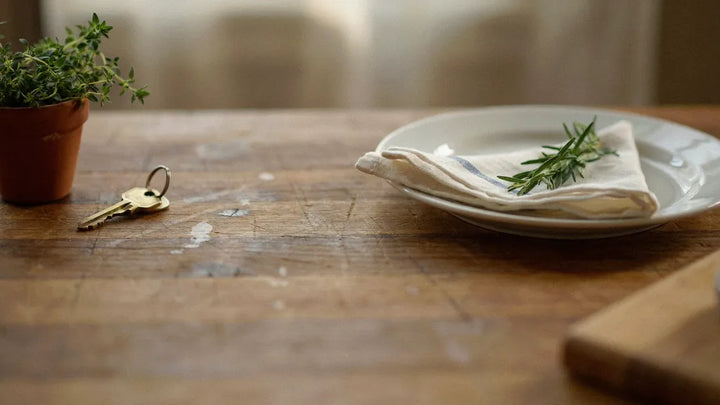 A spare house key on a ring next to a covered plate left out on a kitchen counter