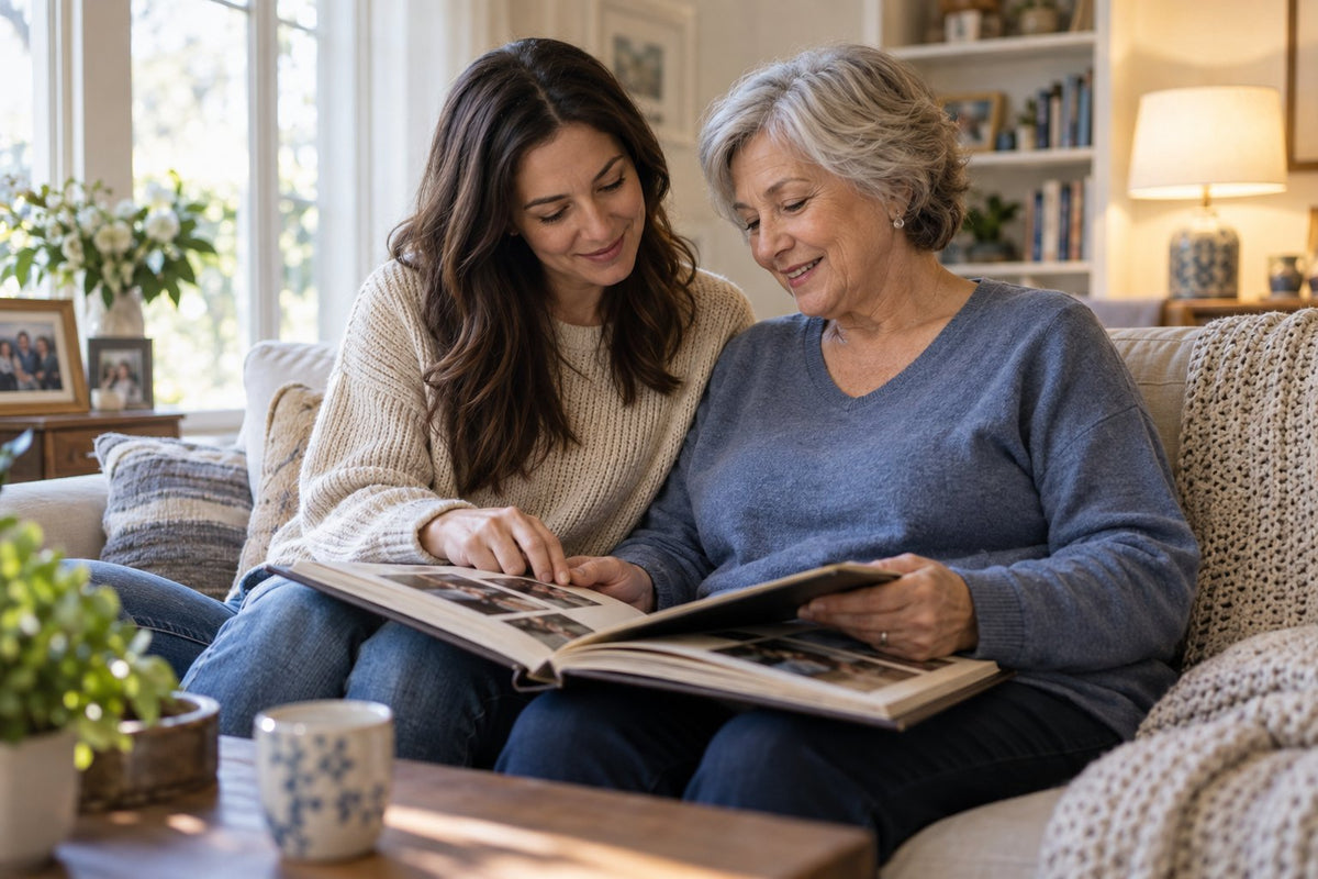 An older woman and a younger woman sharing a photo album at home.