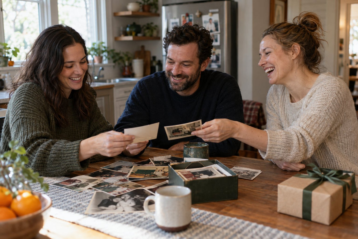 Three adults sharing childhood photographs at a kitchen table.