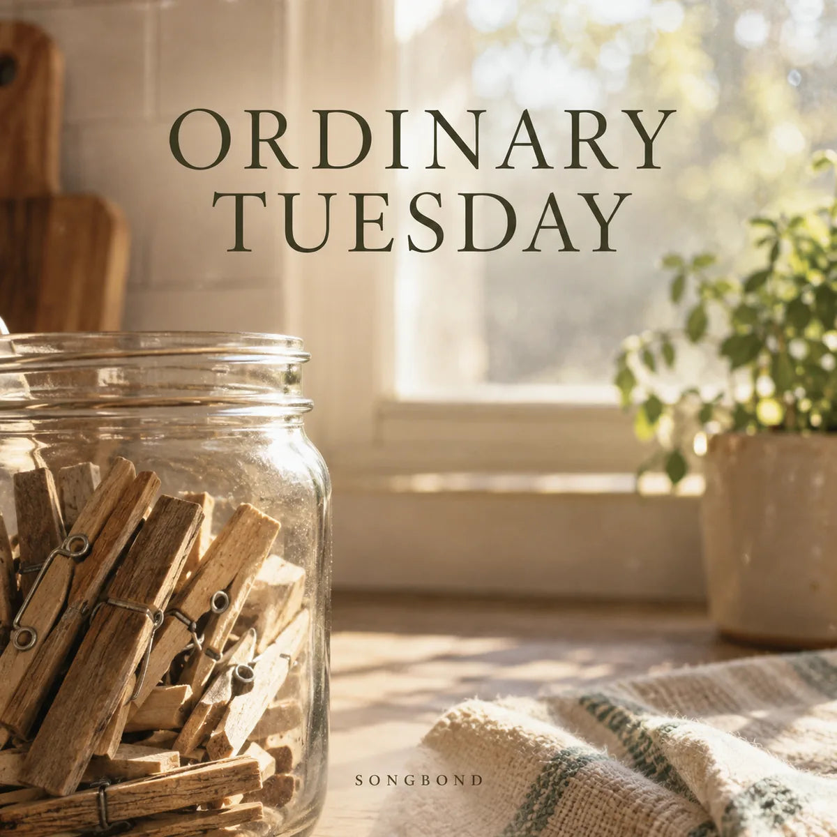 Music cover for Ordinary Tuesday by Songbond, with wooden clothespins in a glass jar on a sunlit kitchen counter beneath the dark serif title.