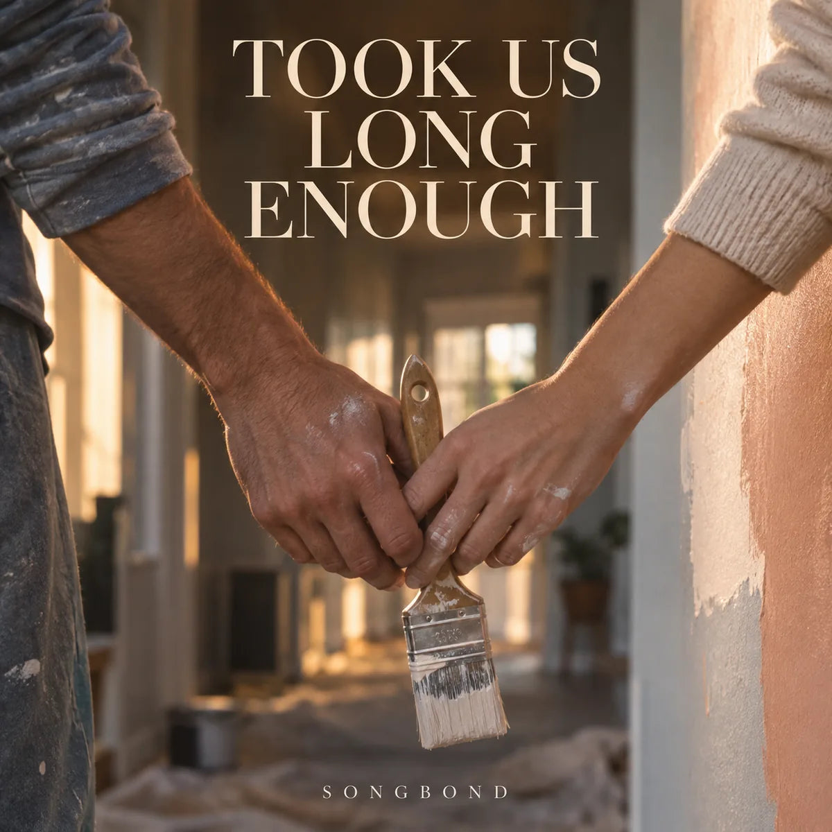 Music cover for Took Us Long Enough: two adults' paint-marked hands hold one paintbrush together in a sunlit hallway, below the full cream title.